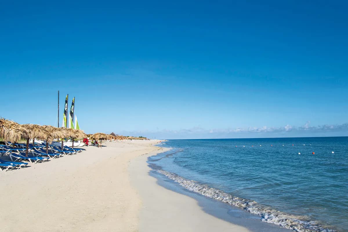 Plaża przy hotelu Meliá Marina Varadero na Kubie z parasolami z liści palmowych, leżakami i katamaranami nad błękitnym morzem