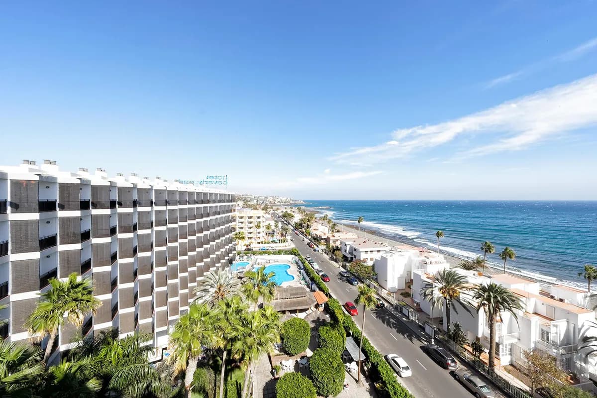 Widok z góry na hotel Relaxia Beverly Park w Playa del Inglés na Gran Canarii: basen wśród palm, nadmorska ulica i ocean