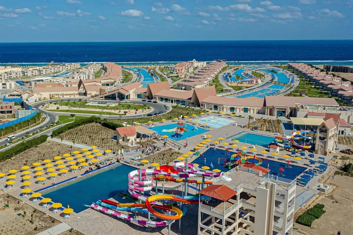 Widok z lotu ptaka na hotel Albatros Sea World w Marsa Alam: baseny, kolorowe zjeżdżalnie i żółte parasole, w tle Morze Czerwone