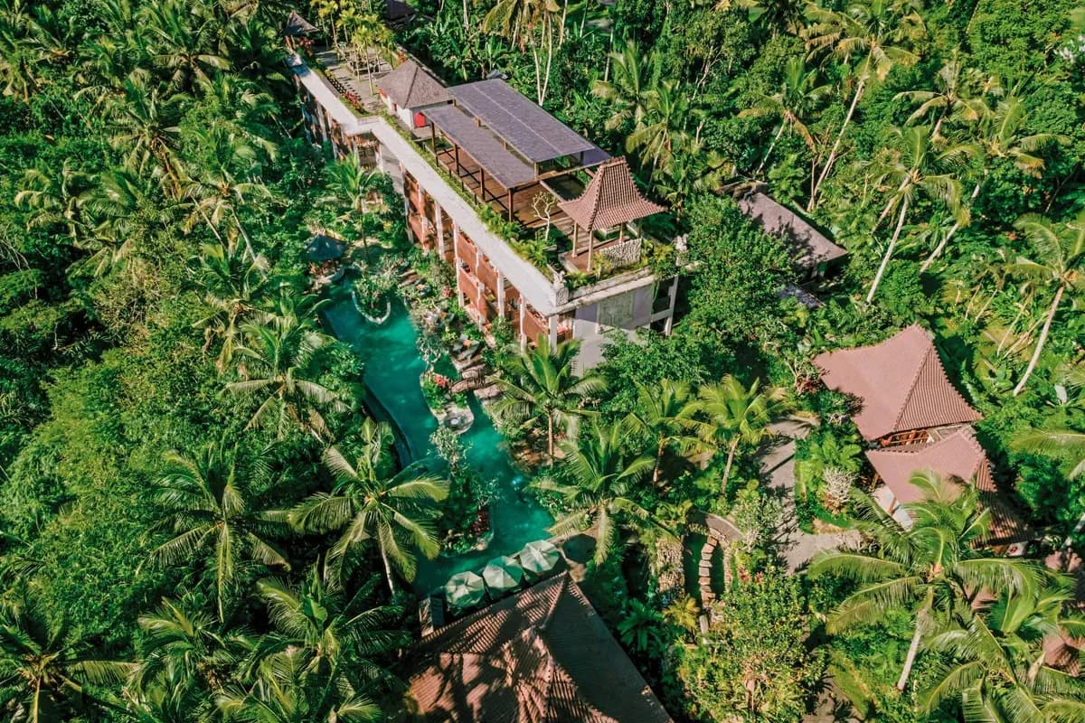 Hotel Arkamara w okolicach Ubud na Bali z lotu ptaka: budynek i turkusowy basen otoczone gęstą dżunglą i palmami kokosowymi