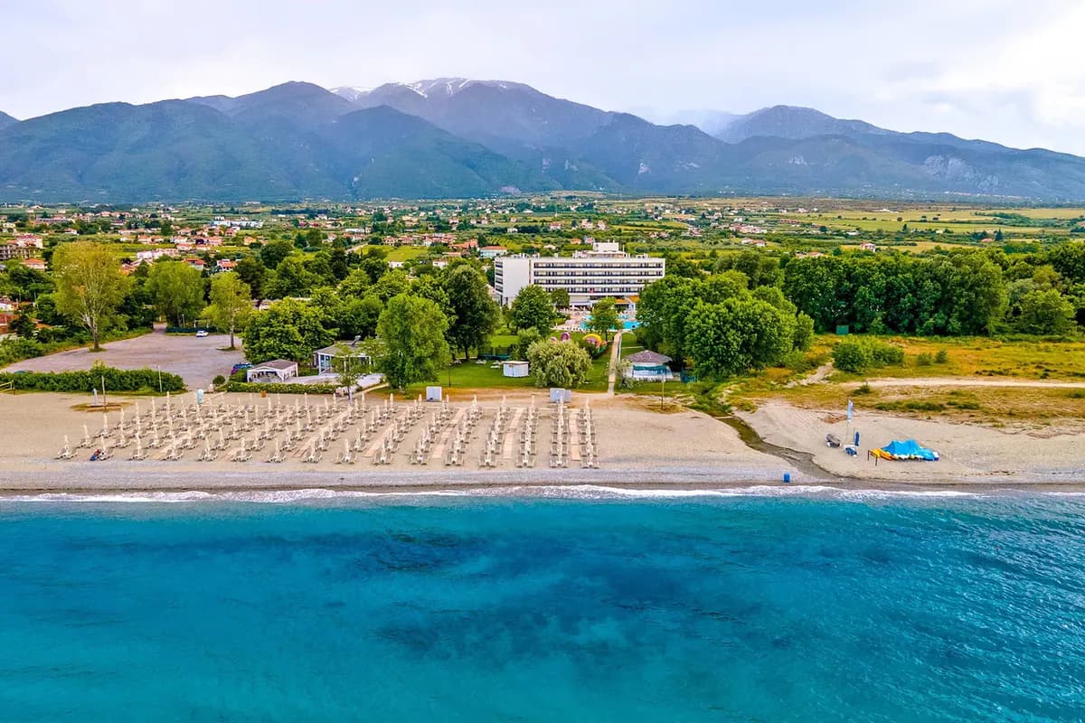 Hotel w Leptokarii z lotu ptaka: plaża z rzędami leżaków, turkusowe morze i zielona równina u stóp masywu Olimpu