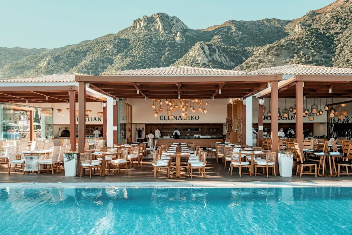 Restauracje hotelu Mitsis Selection Blue Domes na Kos: zadaszony taras z kuchnią włoską i grecką nad basenem, w tle góry