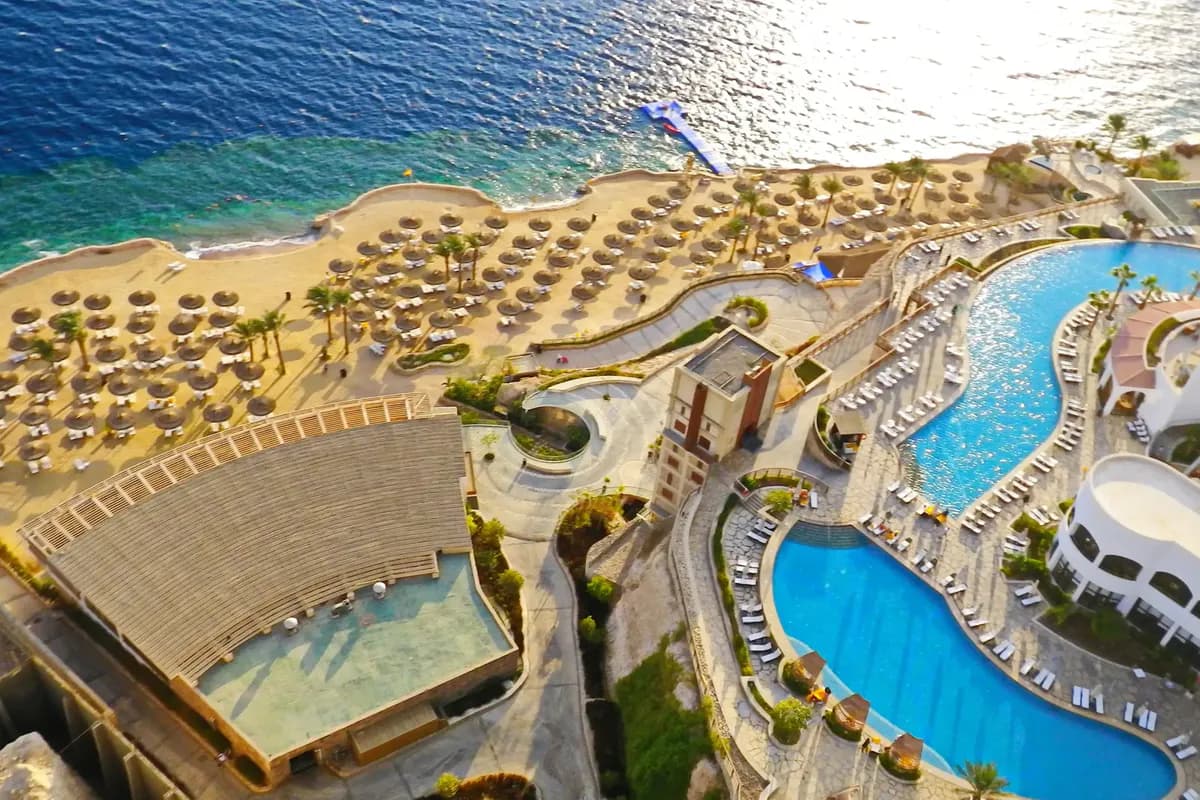 Widok z góry na hotel Reef Oasis Blue Bay w Szarm el-Szejk: baseny, plaża z parasolami i turkusowa rafa w Morzu Czerwonym